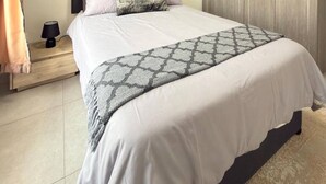 Una camera da letto con un letto, comodini, un armadio e decorazioni alle pareti.
