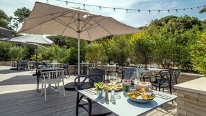 Eine Terrassengaststätte mit Tischen, Stühlen und Lichterketten.