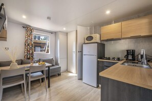 Eine kleine Küche mit Kühlschrank, Mikrowelle und Kaffeemaschine.