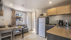 A compact kitchen with a refrigerator, microwave, and coffee maker. - Village - Climatisé - 4p (3) (Le Bois-Plage-en-Ré)