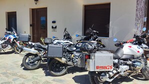 Une rangée de motos est garée devant un bâtiment dont l’entrée est ornée de carreaux.