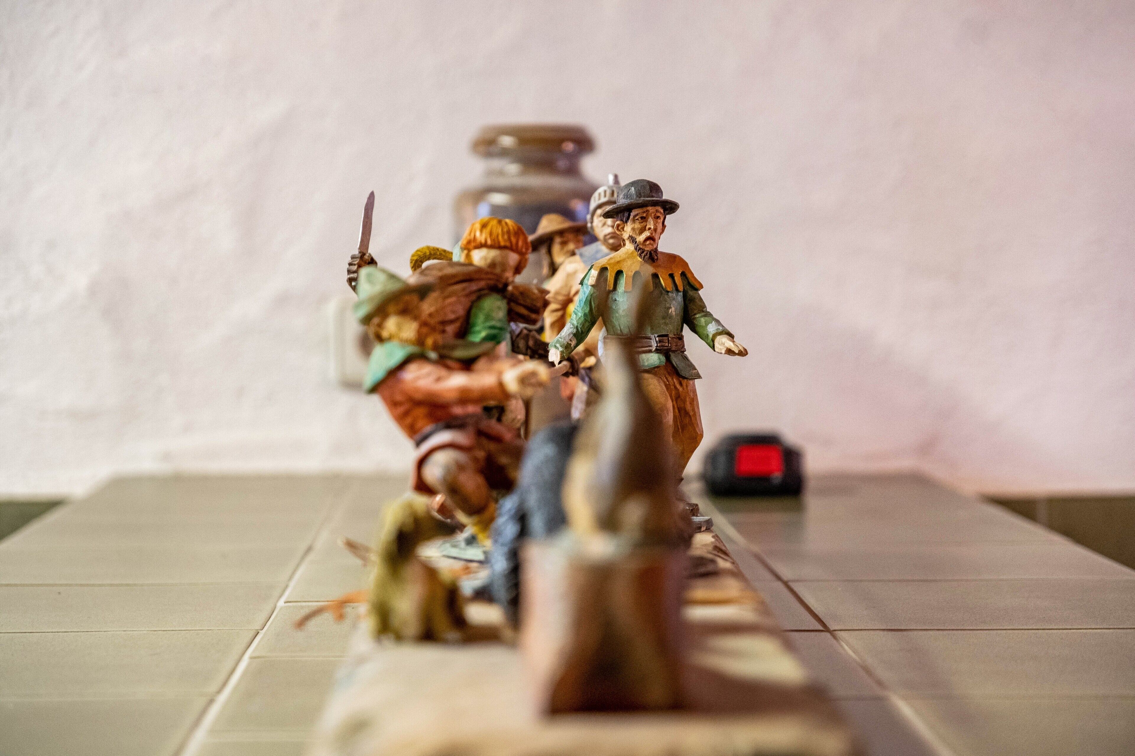 Ein Tisch mit Miniaturfiguren, einer Uhr und unscharfem Hintergrund.