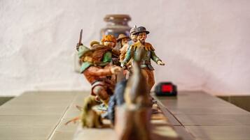 Ein Tisch mit Miniaturfiguren, einer Uhr und unscharfem Hintergrund.