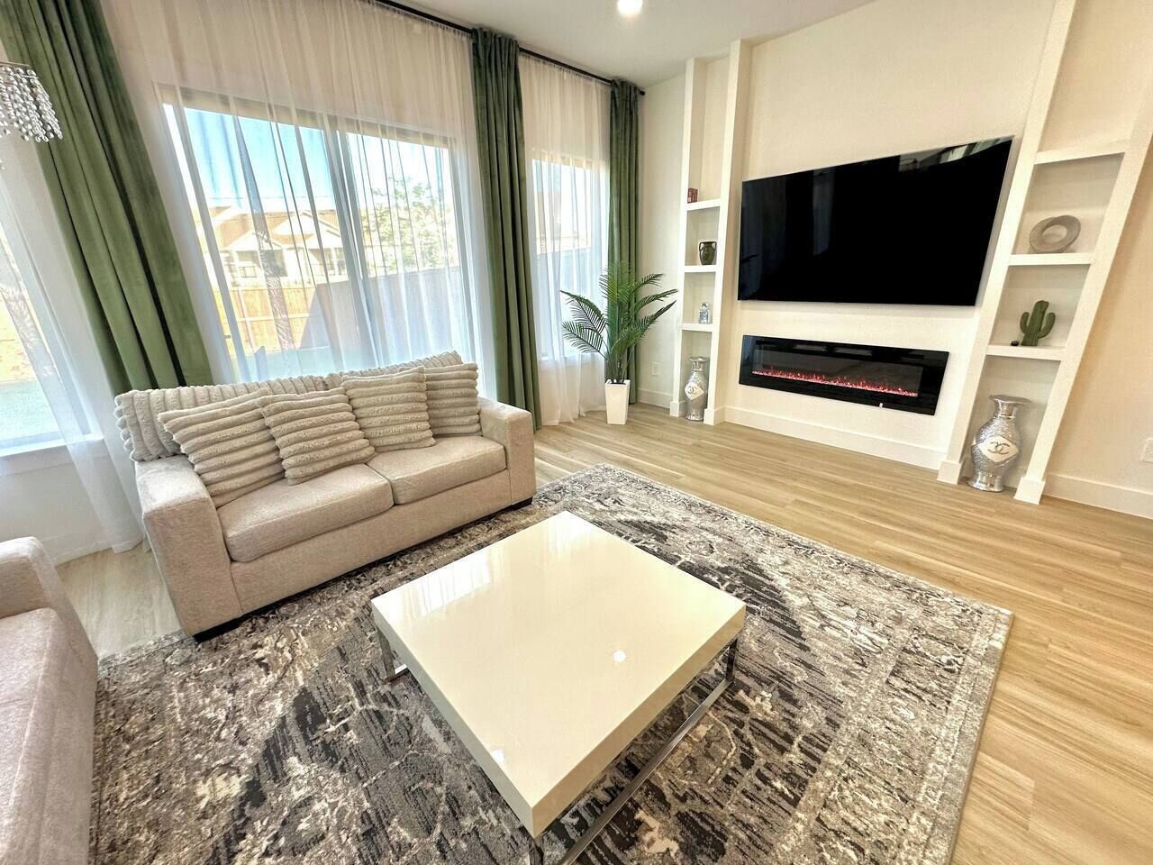 A living room with a sofa, a coffee table, a TV, and a fireplace.