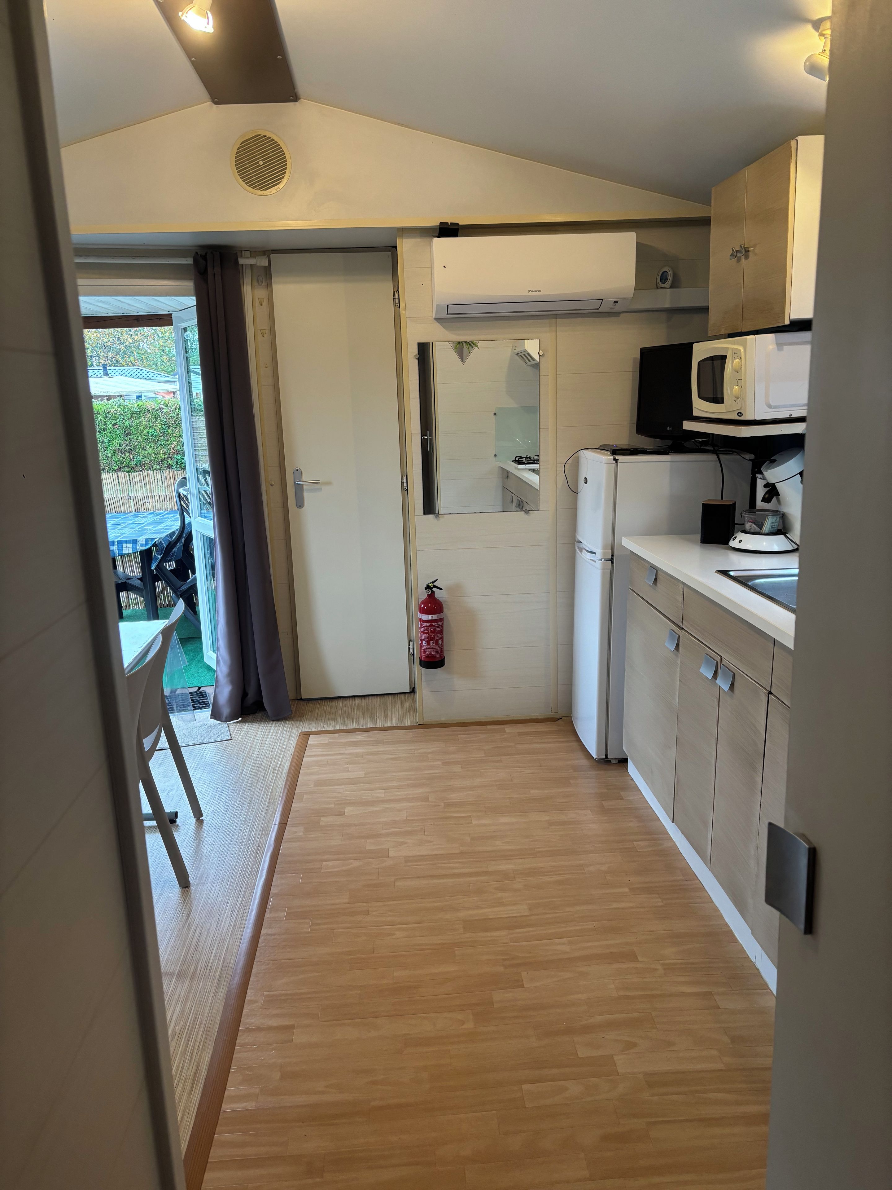 A compact kitchen with a microwave, stove, and a small refrigerator.