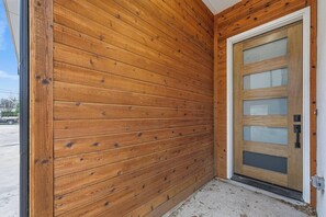 Ein Gebäudeeck mit Holzverkleidung und Glastür.