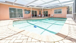 Ein überdachter Pool mit Terrassenbereich, Deckenventilator und Wandgemälde.