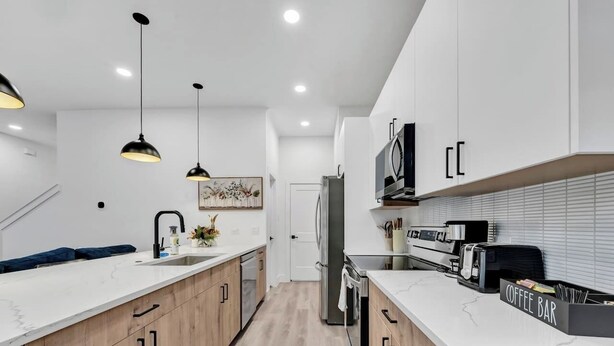 A modern kitchen with wooden cabinets, a white countertop, and a coffee bar. - Fresh Modern 3BR • Rooftop • 5 min to Downtown (Dallas)