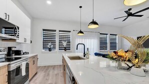 A modern kitchen with a central island, stainless steel appliances, and pendant lighting. - Fresh Modern 3BR • Rooftop • 5 min to Downtown (Dallas)