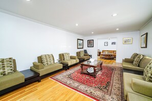 A living room with sofas, a coffee table, and a red rug.