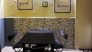 A dining area with a table and chairs, two framed inspirational quotes on the wall, and a patterned tile backsplash. - Spàzio apartments Duomo I (Catania)