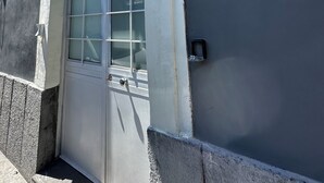 A building with a large window, a door, and a small outdoor area. - Spàzio apartments Duomo I (Catania)