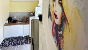 A modern kitchen with a yellow wall, a sink, and a countertop. - Spàzio apartments Duomo I (Catania)