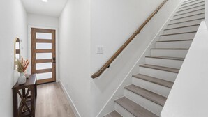 Eine Treppe mit Holzwangen und einer weißen Wand.