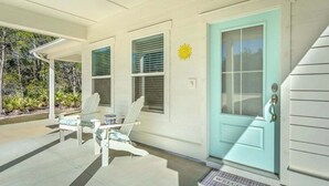A house with a covered porch, a blue door, and a welcome mat. - Sea Breeze Two - Pet Friendly - New Eastpoint (Eastpoint)