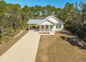 A single-story house with a covered porch, a visible garage, and a well-maintained lawn. - Sea Breeze Two - Pet Friendly - New Eastpoint (Eastpoint)