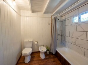 Un baño con inodoro, bidé y bañera.