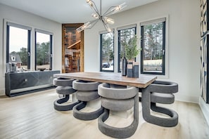 A modern kitchen with a large island, a unique seating arrangement, and a contemporary light fixture. - Serenity Estates in South Fulton (Atlanta)