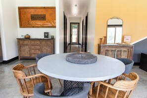 A round dining table with a stone centerpiece, surrounded by wooden chairs with cushioned seats. - 3-bedroom vacation home on Merritt's Mill Pond in Marianna with yard and dock. (Marianna)