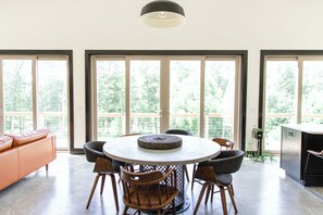 Un comedor con una mesa redonda, sillas y un adorno central.