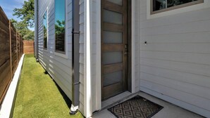 Ein Haus mit Holztür, einem Fenster und einer kleinen Veranda.