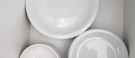A box containing three white plates of varying sizes.