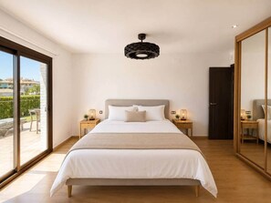 A bedroom with a large bed, a ceiling light fixture, and a sliding glass door leading to an outdoor area. - Villa with Private Pool and Mediterranean Gardens (La Capellania)