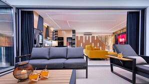 Ein modernes Wohnzimmer mit einer Couch, Sesseln, einem Couchtisch und einem Fernseher.