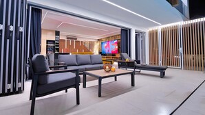 Ein modernes Wohnzimmer mit Sofa, Couchtisch und Fernseher.
