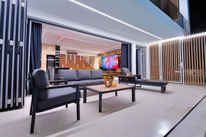 A modern living room with a sofa, coffee table, and TV. - Villa Morena (Vodice)