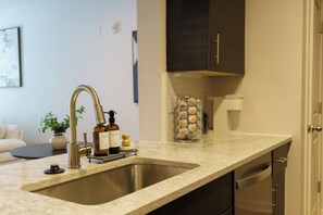 A kitchen with a double sink, a coffee machine, and a cabinet above the counter.