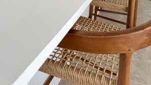 Una cocina moderna con armarios blancos, electrodomésticos de acero inoxidable y una encimera blanca larga.