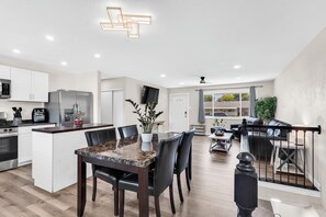 A modern kitchen with white cabinets, a built-in oven, and a stainless steel refrigerator. - A New, Modern & Spacious 6-bedroom house in peaceful Pueblo (Pueblo)