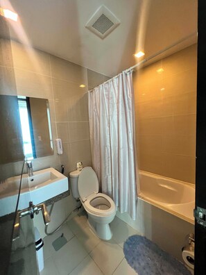 A bathroom with a sink, toilet, and bathtub. - Mactan Infinity Pool View|Near Airport & Beach (Lapu-Lapu)