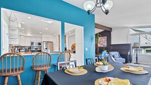 A dining area with a black tablecloth, wooden chairs, and a kitchen in the background. - Seattle Skyline & Lake Retreat | 3Bd/3Ba (Seattle)