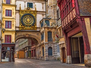 A historic street with ornate architecture, including a prominent clock tower and a traditional archway. - Shelter 2 - joli studio proche gare (Rouen)