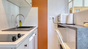 Eine moderne Küche mit Spüle, Wasserhahn und Mikrowelle.
