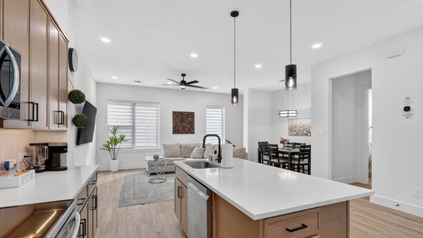 A modern kitchen with a large island, built-in appliances, and a dining area with a table and chairs. - 2BR Retreat | 5 Min Downtown + Medical District (Dallas)