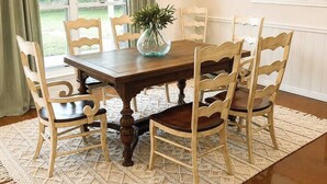 A dining room with a wooden table, six chairs, a vase with greenery, a chandelier, and a view of greenery outside. - Shady Pecan Farmside (Red Oak)