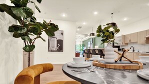 Een moderne keuken met een marmeren aanrecht, houten kastjes en een centraal eiland met zitplaatsen.