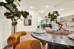 A modern kitchen with a marble countertop, wooden cabinets, and a central island with seating. - Cozy Modern 1BR in Downtown OTR, GYM, POOL (Cincinnati)