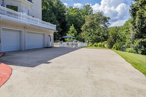 A residential property with a two-story building, a covered patio, and a driveway leading to a garage.