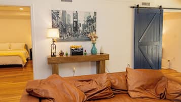 A bedroom with a bed, a nightstand, a lamp, a picture, and a sliding door.