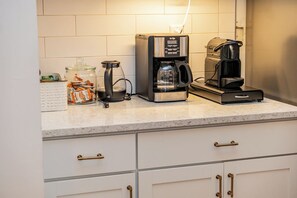A kitchen with a coffee maker, a glass carafe, and a jar of snacks on the counter. - The New Amsterdam Nook: European-inspired guest suite in Mechanicsville. Features 2 bedrooms, 1 spa-like bath, full kitchen, indoor fireplace, dedicated workspace. Enjoy a large yard with pool, hot tub, playground, and BBQ. Comfortably fits 4-6. (Mechanicsville)