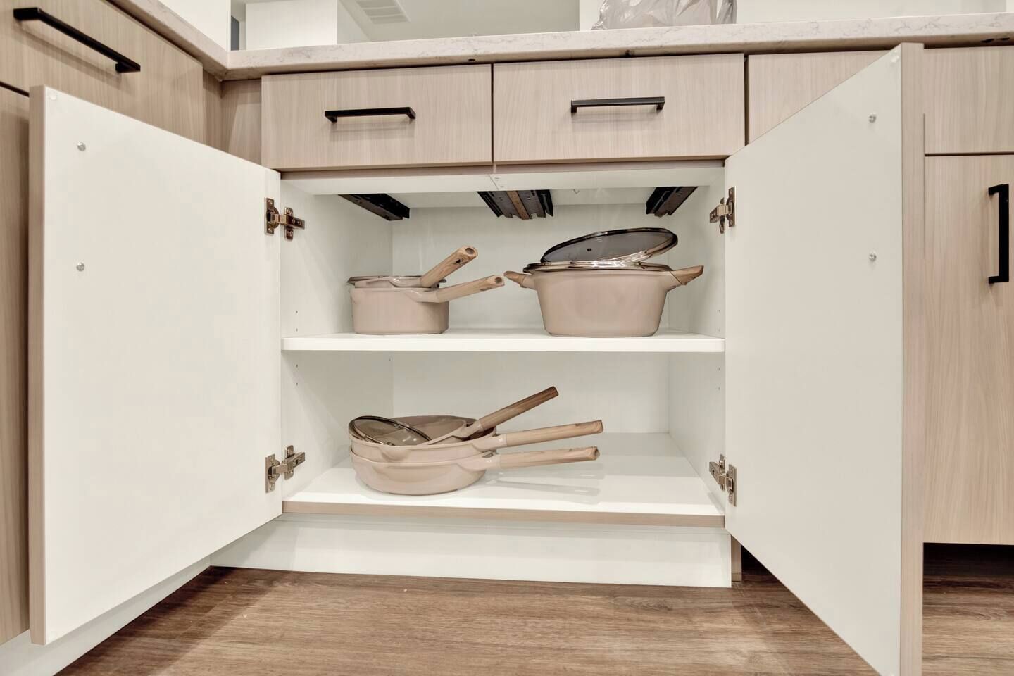 A kitchen with open cabinets revealing cookware.