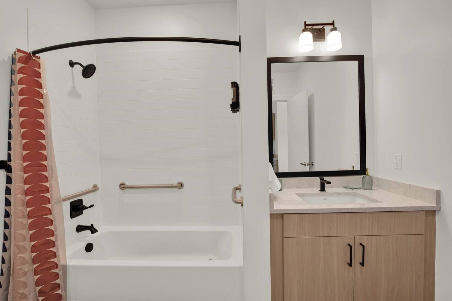 A bathroom with a bathtub, a shower, a sink, and a mirror.