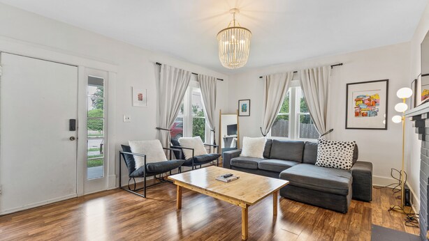 A modern living room with a wooden coffee table, grey sofas, and a chandelier. - 8 Min to Broadway-Hot Tub-Walk to Food &Local Bars (Nashville)
