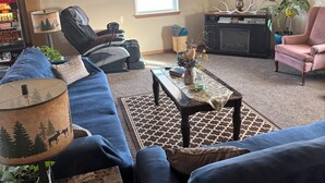Una sala de estar con sofá, mesa de centro, lámpara y televisor.