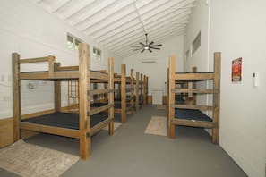 Camas literas en una habitación con paredes blancas y techo inclinado.