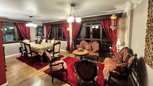 A dining area with a table and chairs, a sofa, and a small round table with a decorative centerpiece. - Vacation Rental (La Paz)
